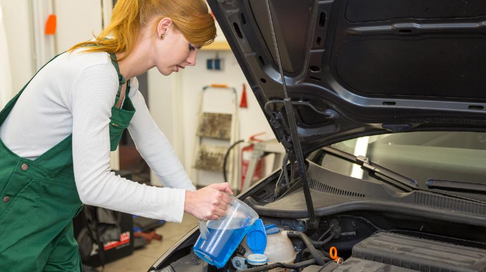 Car maintenance checklist car repairs woman topping up coolant in car
